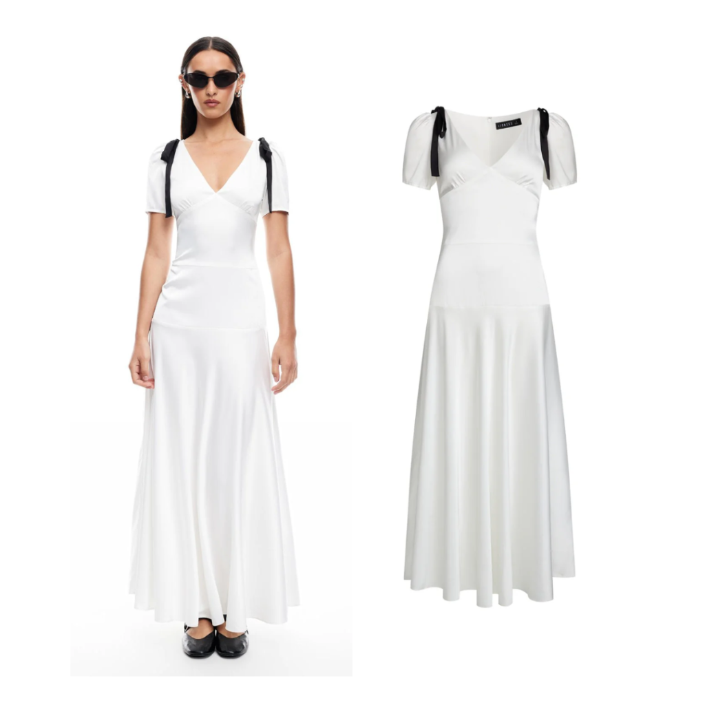 Woman in white silk maxi dress with black bow details on shoulders